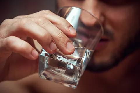 Mann drikker et glass med vann